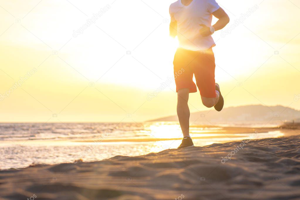 Low section view of man running on beach against sunset sky