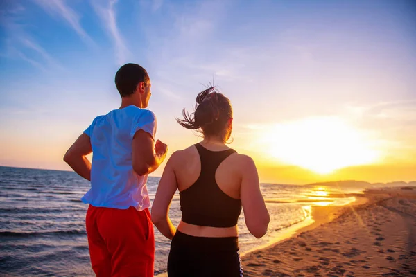 Άνδρες Και Γυναίκες Τρέχουν Στην Τροπική Παραλία Ηλιοβασίλεμα — Φωτογραφία Αρχείου
