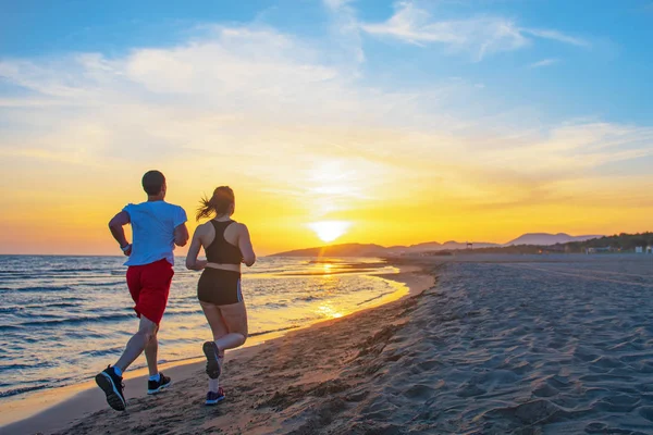 Hombre Mujeres Corriendo Playa Tropical Atardecer —  Fotos de Stock