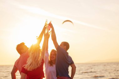 İki çiftler kumsalda günbatımı sırasında dinlenme