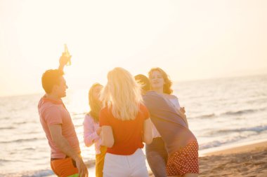 güzel yaz günbatımı sahilde içki ile mutlu gençlerin Grup