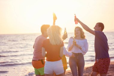 güzel yaz günbatımı sahilde içki ile mutlu gençlerin Grup