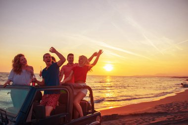 Gençler sırasında günbatımı Plajı'nda arabada eğleniyor