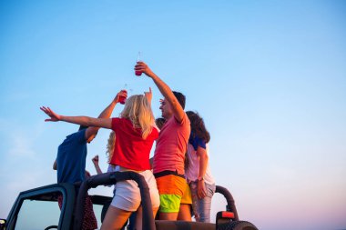 Gençler sırasında günbatımı Plajı'nda arabada eğleniyor