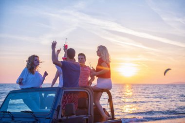 Gençler sırasında günbatımı Plajı'nda arabada eğleniyor