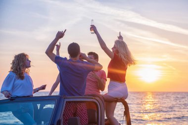 Gençler sırasında günbatımı Plajı'nda arabada eğleniyor