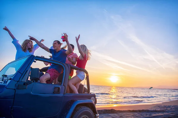 Νέοι Διασκεδάζουν Στο Αυτοκίνητο Στην Παραλία Κατά Διάρκεια Του Ηλιοβασιλέματος — Φωτογραφία Αρχείου