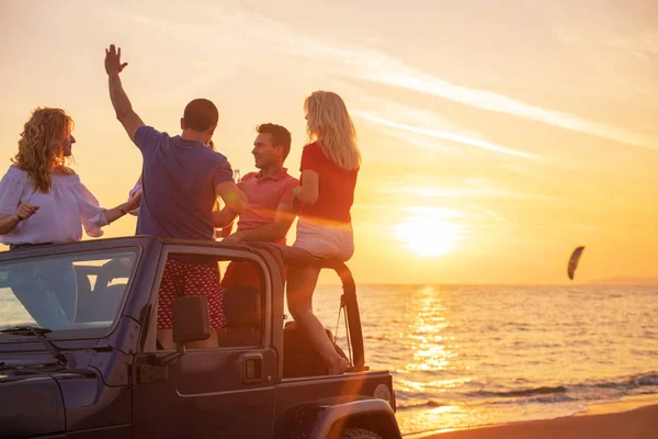 Νέοι Διασκεδάζουν Στο Αυτοκίνητο Στην Παραλία Κατά Διάρκεια Του Ηλιοβασιλέματος — Φωτογραφία Αρχείου