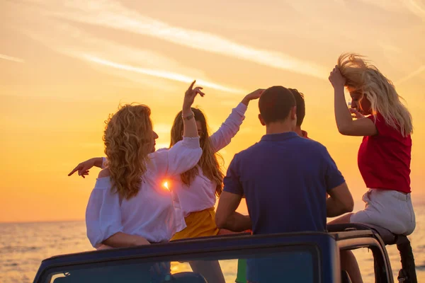 Grupo Jóvenes Con Bebidas Divirtiéndose Coche Descapotable Playa Atardecer — Foto de Stock