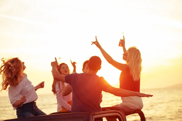 Grupo Jóvenes Con Bebidas Divirtiéndose Coche Descapotable Playa Atardecer — Foto de Stock