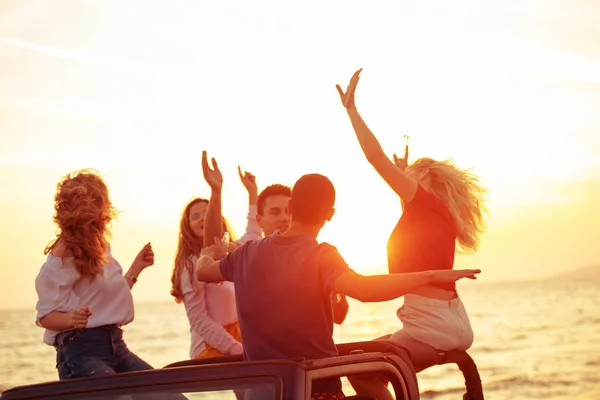 Groep Jongeren Met Plezier Converteerbare Auto Het Strand Tijdens Zonsondergang — Stockfoto