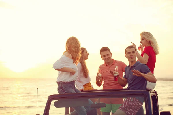 Groep Jongeren Met Plezier Converteerbare Auto Het Strand Tijdens Zonsondergang — Stockfoto