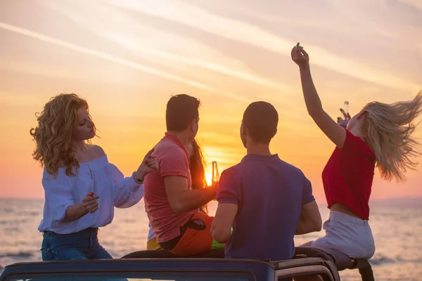 Groep Jongeren Met Plezier Converteerbare Auto Strand Tijdens Zonsondergang Drankjes — Stockfoto