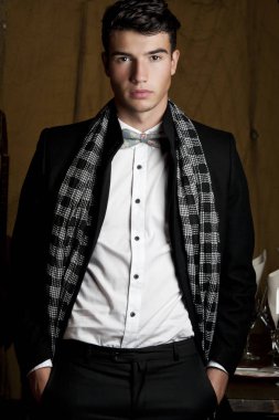 Takım elbise ve şapka ve güneş gözlüğü takan genç adam.