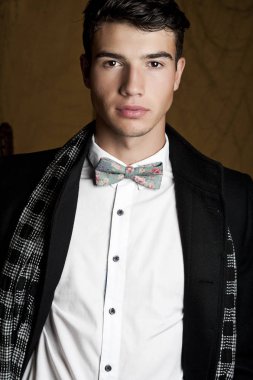 Takım elbise ve şapka ve güneş gözlüğü takan genç adam.