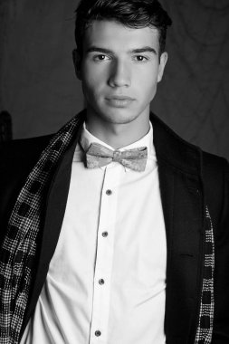 Takım elbise ve şapka ve güneş gözlüğü takan genç adam.