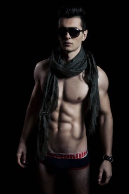 Takım elbise ve şapka ve güneş gözlüğü takan genç adam.