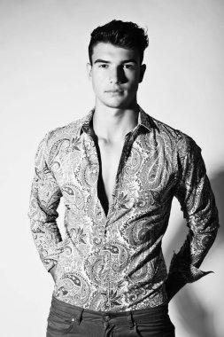 Takım elbise ve şapka ve güneş gözlüğü takan genç adam.