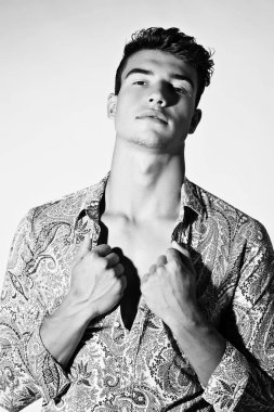 Takım elbise ve şapka ve güneş gözlüğü takan genç adam.