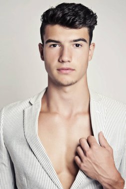 Takım elbise ve şapka ve güneş gözlüğü takan genç adam.