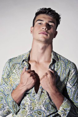 Takım elbise ve şapka ve güneş gözlüğü takan genç adam.