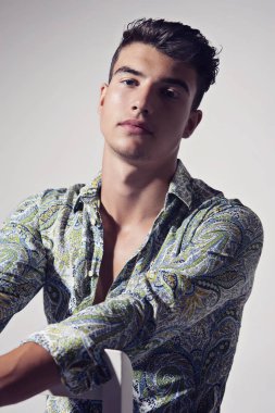 Takım elbise ve şapka ve güneş gözlüğü takan genç adam.