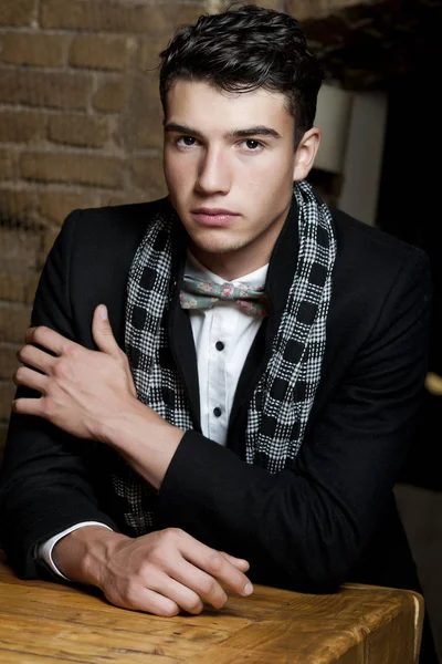 Takım elbise ve şapka ve güneş gözlüğü takan genç adam.