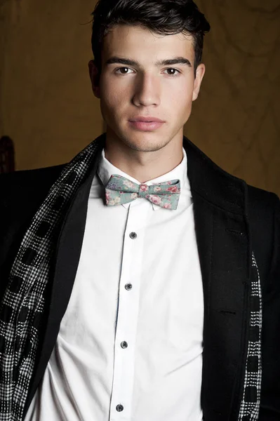 Takım elbise ve şapka ve güneş gözlüğü takan genç adam.