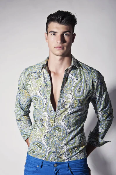 Takım elbise ve şapka ve güneş gözlüğü takan genç adam.