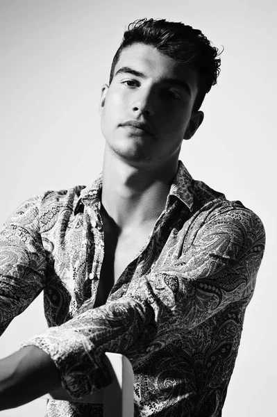 Takım elbise ve şapka ve güneş gözlüğü takan genç adam.