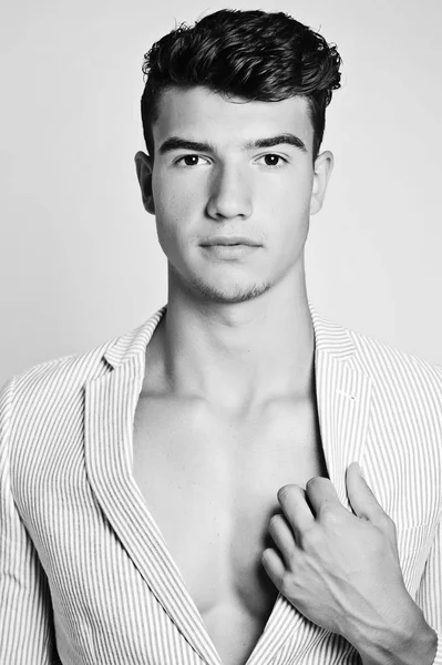 Takım elbise ve şapka ve güneş gözlüğü takan genç adam.