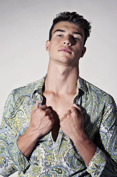 Takım elbise ve şapka ve güneş gözlüğü takan genç adam.