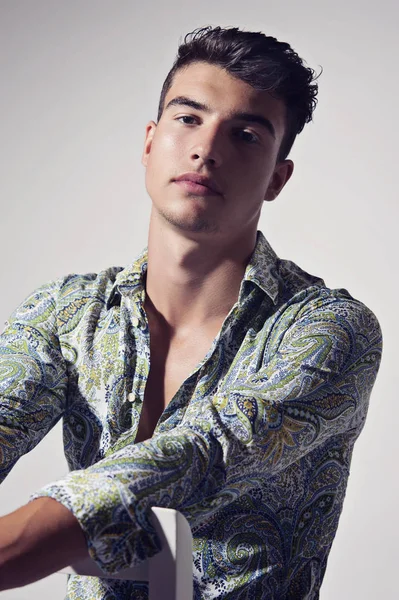 Takım elbise ve şapka ve güneş gözlüğü takan genç adam.