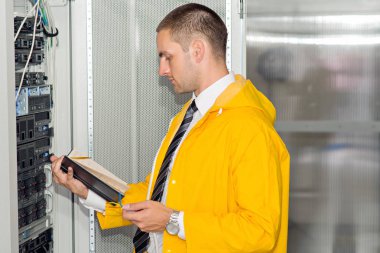 Genç yakışıklı iş adamı veritabanı sunucu odasında.