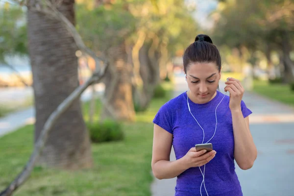 Portret Zbliżenie Młodych Kobiet Runner Niebieską Koszulkę Słuchanie Muzyki Słuchawki — Zdjęcie stockowe