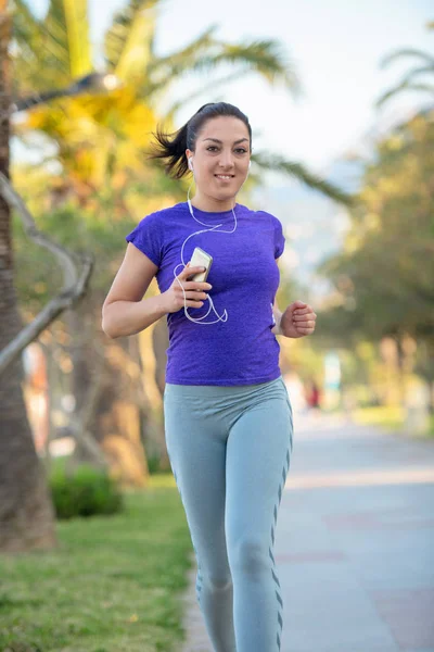 Smiling Female Runner Listening Music Earphones While Running Outdoors Training — Stock Photo, Image
