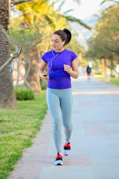 Young Female Runner Listening Music Earphones While Running Outdoors Training — Stock Photo, Image
