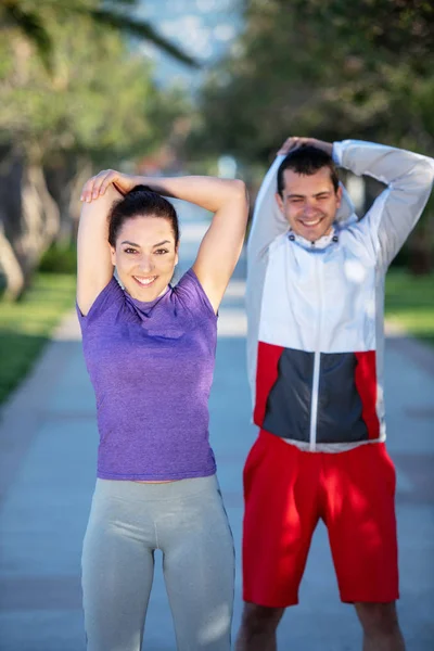ウォーミング アップやストレッチを実行して朝の前にジョギングの若いカップル — ストック写真