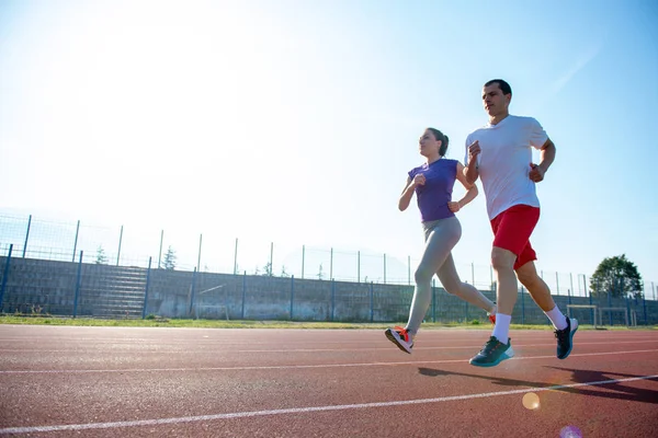 Joven Pareja Deportiva Trotando Pista Atletismo Estadio —  Fotos de Stock