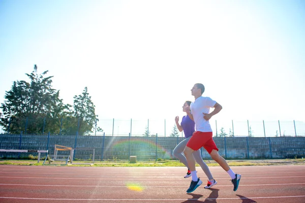 Jovem Casal Desportivo Correndo Pista Corrida Estádio Dia Ensolarado — Fotografia de Stock