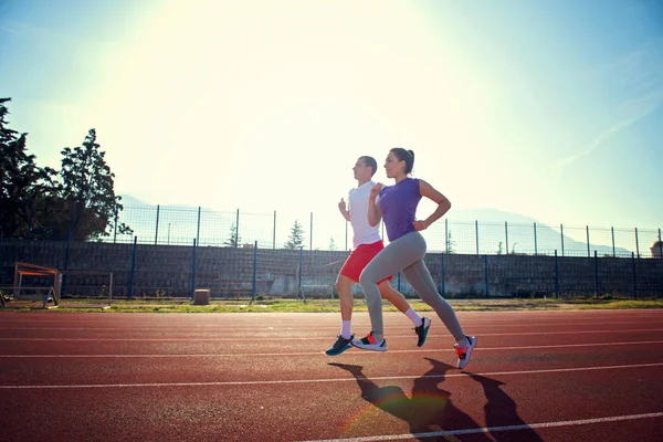 Jovem Casal Desportivo Correndo Pista Corrida Estádio Dia Ensolarado — Fotografia de Stock