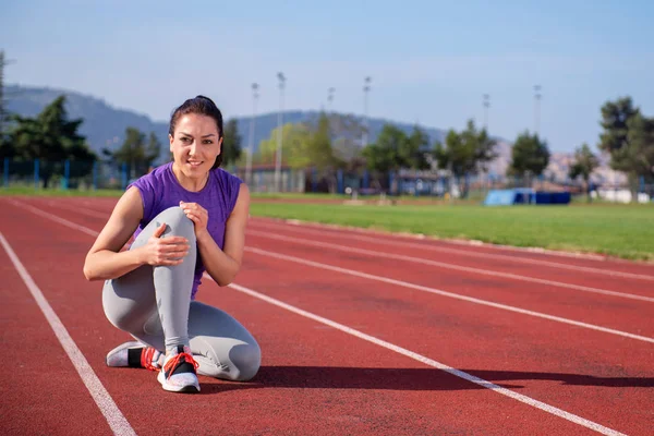 Corredor Femenino Sosteniendo Rodilla Lesionada —  Fotos de Stock