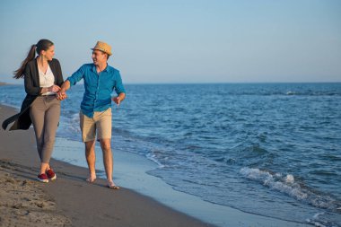 Yaz giysileri birlikte deniz kıyısında yürüyen genç mutlu çift