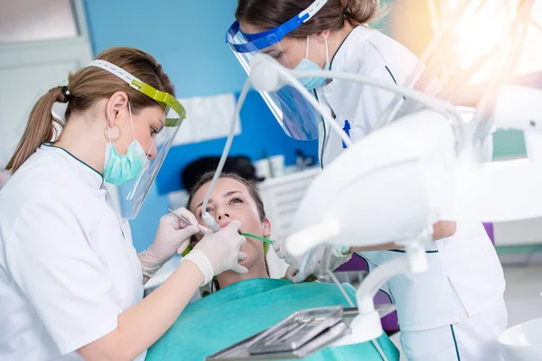 Female dentists and young woman patient in dentist office