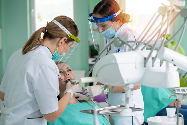 Female dentists and young woman patient in dentist office  