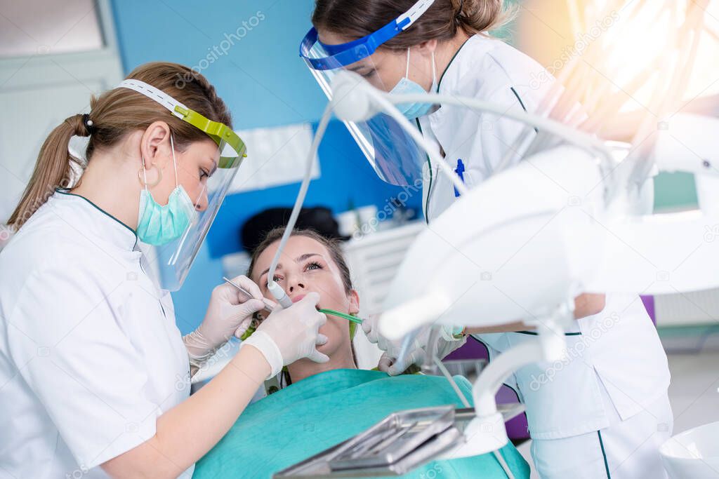 Female dentists and young woman patient in dentist office  
