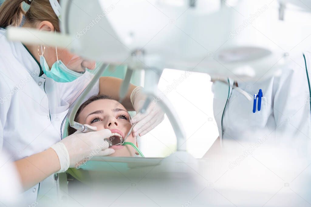 Female dentist and young woman patient in dentist office  