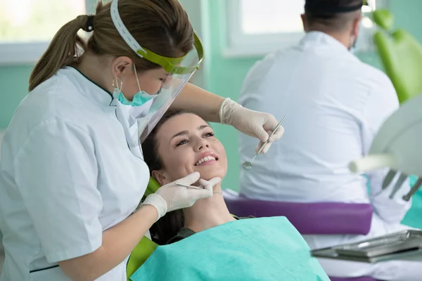 Female dentist and young woman patient in dentist office