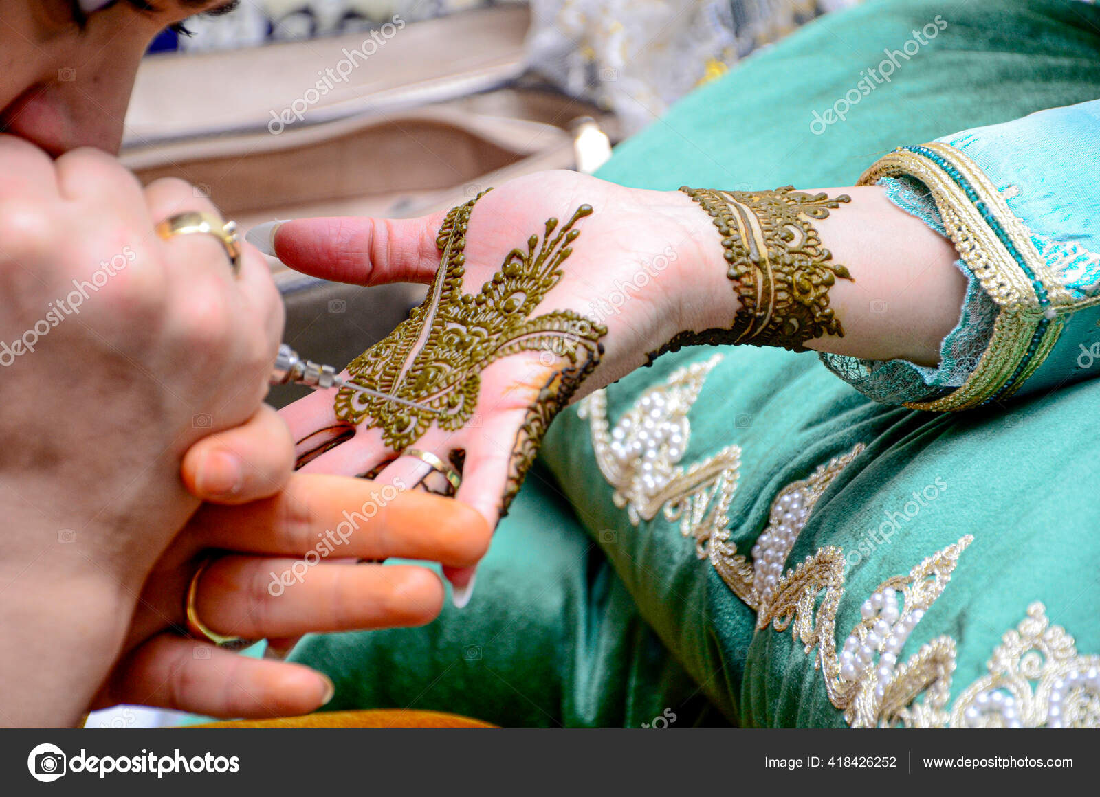 Artista aplicando tatuagem de henna mehndi na mão feminina