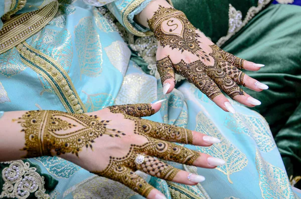 Mehndi tattoo. Woman Hands with black henna tattoos. moroccan national traditions.